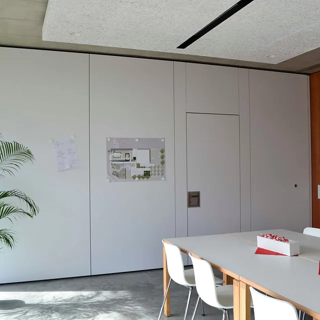Flexible DORRflex-Trennwand in einem modernen Konferenzraum mit weißer Oberfläche und minimalistischer Einrichtung.